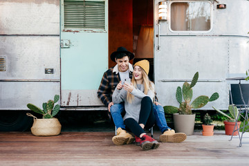 Young couple using smartphone near van