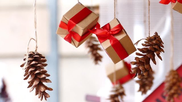Hanging presents with red ribbon and pine cones in traditional Christmas market