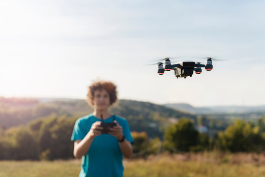 Boy navigating flying drone outdoors