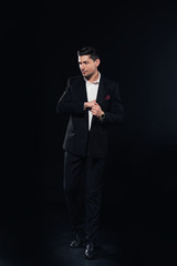 handsome man posing in suit isolated on black