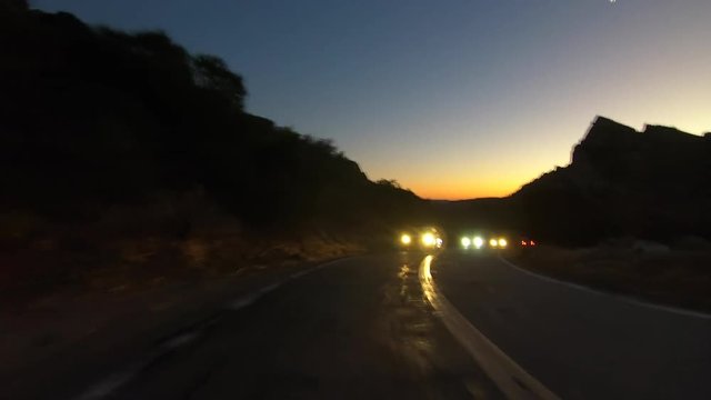Dusk rear view driving past rocks and peaks on Box Canyon road between Los Angeles and Simi Valley in Southern California. 