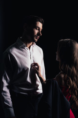 woman gently touching handsome man isolated on black