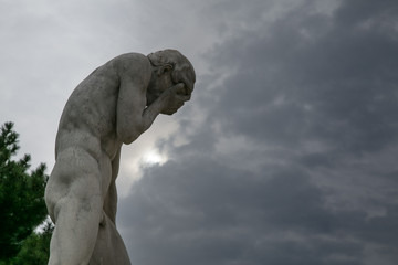 Fototapeta premium posąg mężczyzny trzymającego twarz w ogrodzie Tuileries w Paryżu
