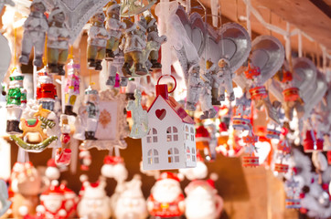 hanging wooden and ceramic toys on the street christmas market