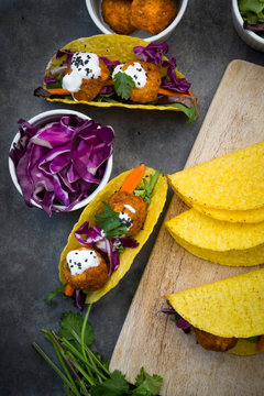 Sweet potato falafel in taco shells, with red cabbage, salad, carrot, yogurt sauce and black sesame