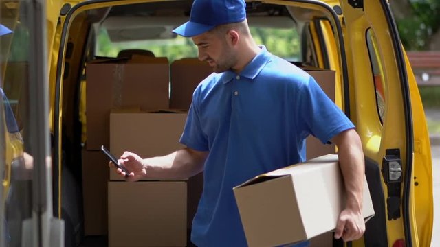 Courier hold box and taxt on phone.