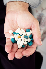 senior man with a pile of pills in his hand