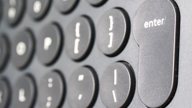 Closeup of finger pressing enter button on the black computer keyboard. Technology