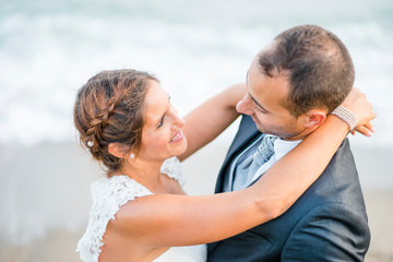 Fototapeta premium Newlywed couple hugging each other on the beach