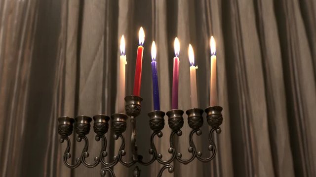 Six candles in hanukkiah are burning on light curtain background on the fifth day of the Jewish holiday Hanukkah. Selective focus. 4k