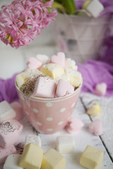 A cup of latte with hart-shaped marshmallows