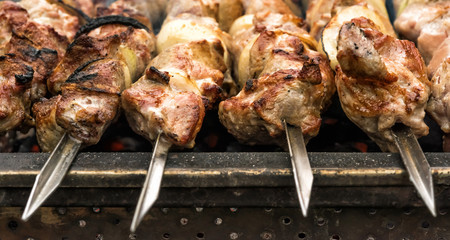 Close-up of hot roasted meat on metal skewers