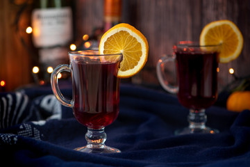 Mulled wine with orange and spices on a dark background.