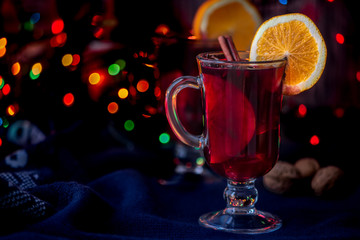 Winter cocktail with oranges and spices. Festive, blurred background. Magical.