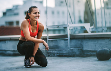 Female athlete sitting on rooftop during fitness training
