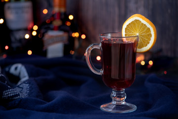 Mulled wine with orange and spices on a dark background.