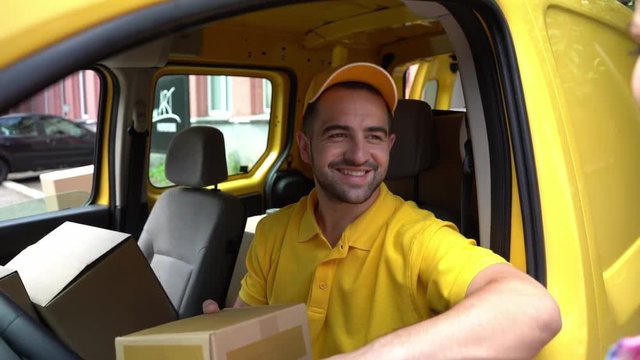 Courier in yellow van gives package to female customer