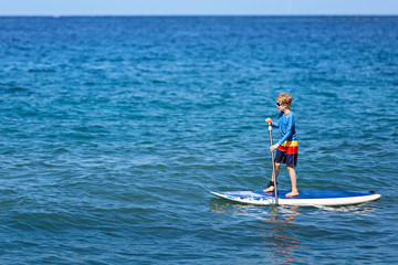 boy stand up paddleboarding