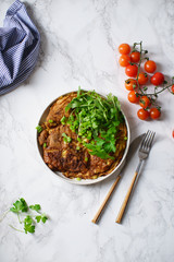 Tortilla omelette with sliced potatoes and herbs on marble table