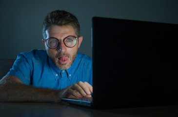 lascivious aroused porn addict man in nerd glasses watching sex movie online late night at laptop...