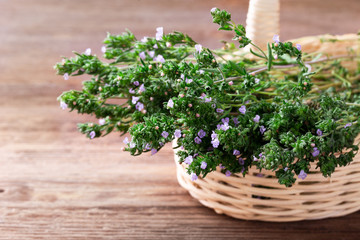 Fresh thyme in a basket over rustic wooden background with copyspace.