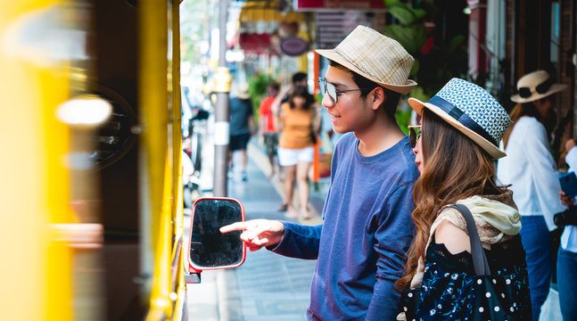 A couple of blogger tourists from Southeast Asia. Visit Phuket in Thailand are Asking Route price from driver in the old town of Phuket during write travel reviews with sunlight in travel concept .