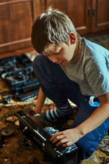 A boy, eight years old, disassembles an old radio