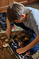 A boy, eight years old, disassembles an old radio