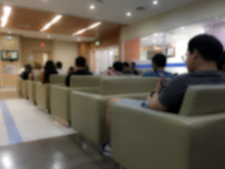 Blurred view and low light. People sitting on the couch waiting to see the doctor for physical examination. In the hospital.