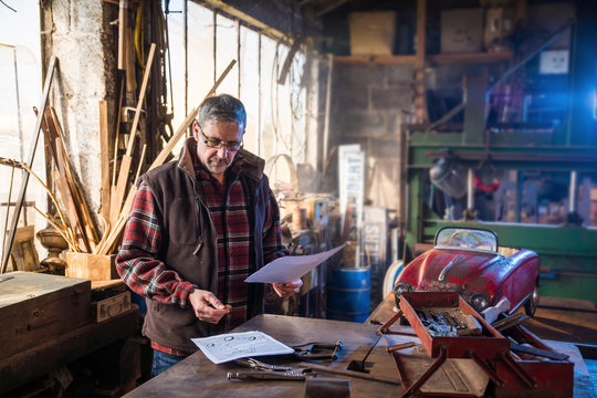 A man in his DIY workshop to repair an old pedal car