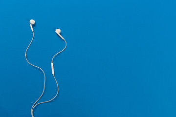 White earphones on blue background