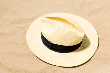 Fototapeta na wymiar summer holidays and vacation concept - straw hat on beach sand