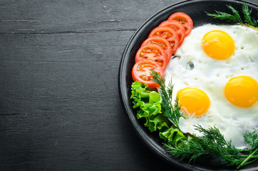 Eggs with tomatoes and fresh vegetables. Breakfast. Top view. Free space for your text.