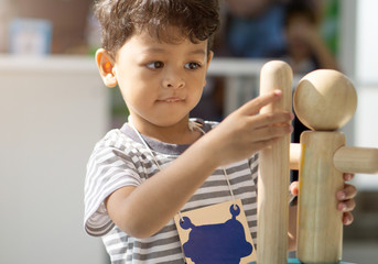 Asian little boy playing with wood toys © pkproject