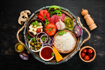 Ingredients for pizza in a wooden box. Top view. On a wooden background. Free copy space.