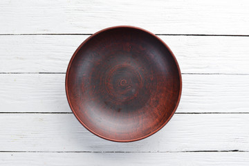 Clay dishes. A plate on a white wooden background. Top view. Free copy space.
