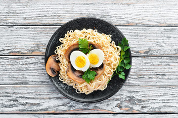 Asian food. Noodles with mushrooms, eggs and chia seeds. On a wooden background. Top view. Free copy space.
