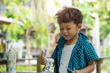 Asian kids enjoying his painting with hands