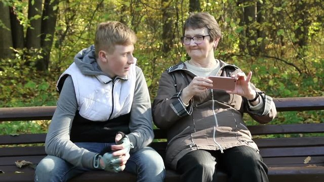 The boy with the grandmother in the autumn park
