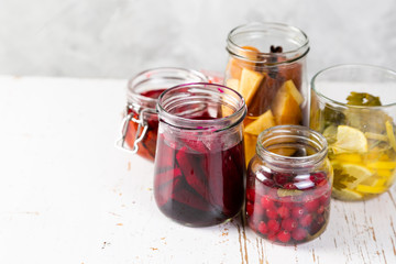 Preparing drinking vinegar infusions in glass jars, copy space