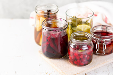 Fototapeta na wymiar Preparing drinking vinegar infusions in glass jars, copy space