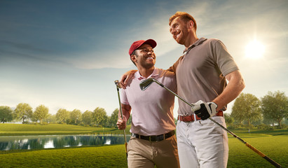 Two male golf players on professional golf course. Smiling golfers with golf clubs