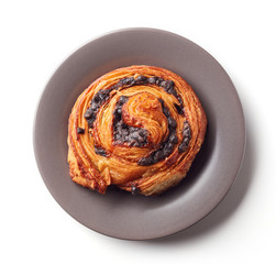 Sweet bun with chocolate chips on grey plate isolated on white, from above