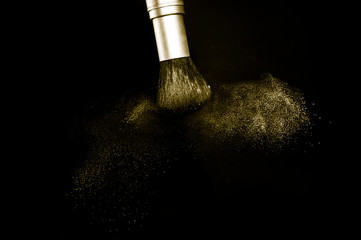 gold powder splash and brush for makeup artist or beauty blogger in black background, look like a luxury