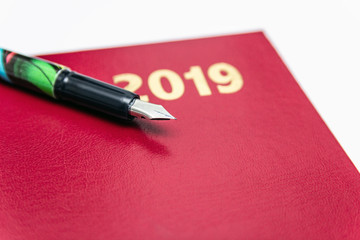 Fototapeta premium Close up of 2019 red leather diarys with fountain pen on white background. isolated on the white