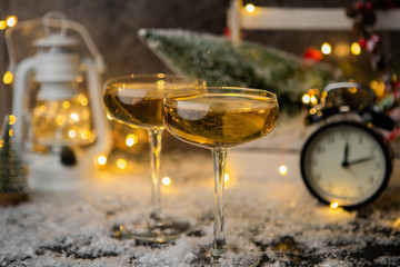 Photo of two wine glasses on blurred background with Christmas tree, lantern, clock