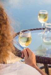 Young man drinking white Portuguese wine by an outdoor table in Tavira, Algarve region, Portugal