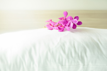 Obraz na płótnie Canvas Pillows and beautiful orchid flower on top in the bed room.