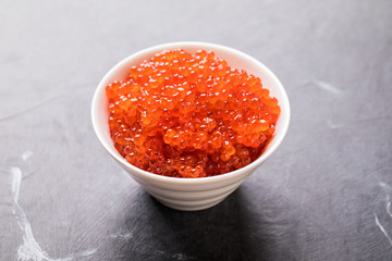 Salmon  Red Caviar in a white plate on a dark background. Healthy Food Concept. Snack.Copy space for Text.Seafood.