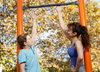 Obraz premium Family doing exercises on horizontal bar